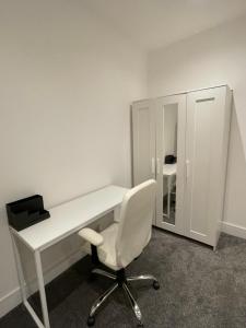 Newly renovated flat in Ashtead في Ashtead: مكتب أبيض مع كرسي ومرآة