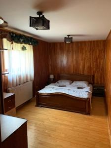 - une chambre avec un lit dans une pièce dotée de murs en bois dans l'établissement Під Боржавою, à Volovets