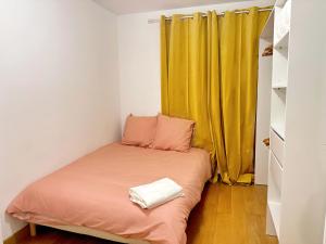 Dormitorio pequeño con cama con cortina amarilla en cozy 3 bedroom apartment dans republique en París