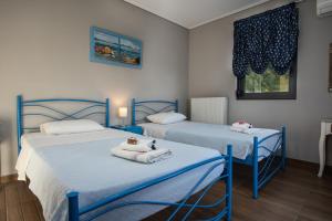 two beds in a room with towels on them at Villa Aggemari in Apidias Lakos