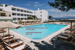 a large swimming pool with chairs and a building at Geralis Lodge in Chalkida