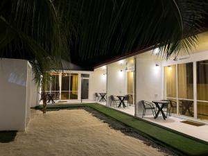 a courtyard with tables and chairs in a building at Vegas Thoddoo Maldives in Thoddoo