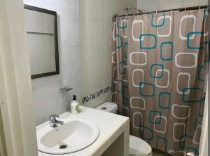 a bathroom with a sink and a shower curtain at Alojamientos OHANA in Oaxaca City