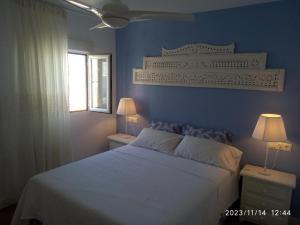 1 dormitorio azul con 1 cama y 2 lámparas en Apartamento Centro Nerja proxi playas, en Nerja