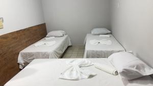 2 camas en una habitación con sábanas blancas en Suítes Tambaú, en João Pessoa
