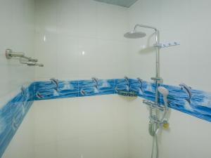 Vegas Thoddoo Maldives في ثودو: دش في الحمام والبلاط الأزرق على الحائط