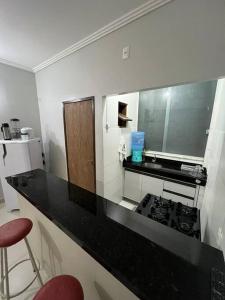 - une cuisine avec un comptoir noir et une cuisinière dans l'établissement Apartamento frente ao mar na praia do guaibim., à Guaibim