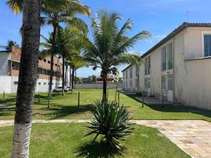 un groupe de palmiers à côté d'un bâtiment dans l'établissement Apartamento frente ao mar na praia do guaibim., à Guaibim