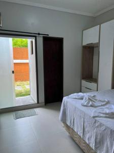 1 dormitorio con cama y espejo grande en Apartamento frente ao mar na praia do guaibim., en Guaibim