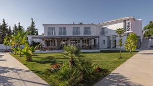 una casa blanca con palmeras delante en Benavista Estepona - 2 Bed Town House with Pool, en Estepona