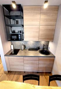 una cocina con fregadero y microondas en Apartment C519 - Aparthotel Vučko Jahorina - Private Host, en Jahorina