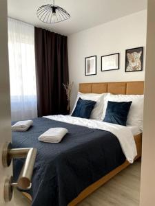 a bedroom with a large bed with blue pillows at SkyNest B404 in Bratislava