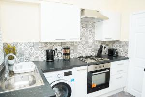 a kitchen with a washing machine and a sink at Modern Retreat Central Location Close to The City in Killingbeck