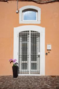 una puerta con una ventana y un jarrón con flores púrpuras en 21 Passi dal Mare, en Gaeta