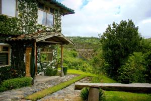 uma casa com um caminho de pedra ao lado de um edifício em Hosteria Cananvalle em Ibarra