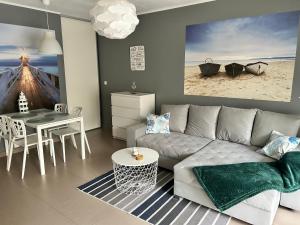 a living room with a couch and a table at Apartament Przy Lesie in Międzywodzie