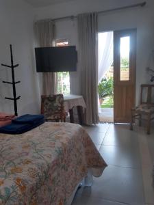 1 dormitorio con cama, mesa y ventana en Vila Sabará en Pinheira