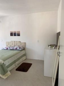 a white room with a bed and a refrigerator at Casa Vista Mar in Governador Celso Ramos