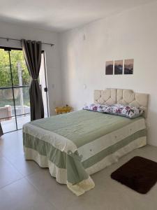 a bedroom with a large bed and a large window at Casa Vista Mar in Governador Celso Ramos