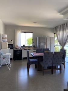 eine Küche und ein Wohnzimmer mit einem Tisch und Stühlen in der Unterkunft Casa Vista Mar in Governador Celso Ramos