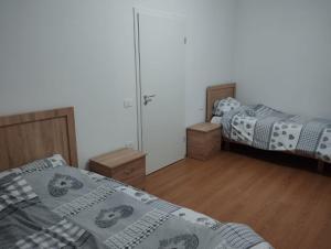 a bedroom with two beds and a mirror at Alban Apartment in Tirana