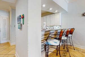 une cuisine avec un bar et des chaises. dans l'établissement Broadmoor 1203, à Orange Beach