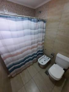 y baño con aseo y cortina de ducha. en Necochea-Casa para hasta 4 personas! en Necochea