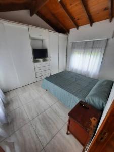 um quarto com uma cama e uma televisão em Necochea-Casa para hasta 4 personas! em Necochea