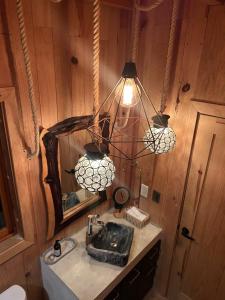 a bathroom with a sink and a mirror and a light at Casa Ágata in El Puertecito