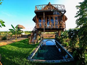 a tree house with a pond in front of it at Casa Ágata in El Puertecito