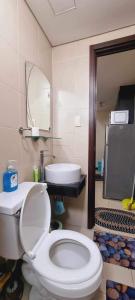 ein Badezimmer mit einem weißen WC und einem Waschbecken in der Unterkunft San Lorenzo place condo in Manila