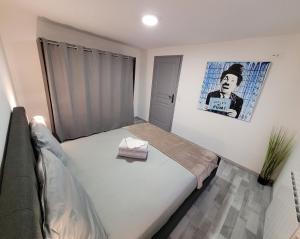 1 dormitorio con 1 cama y una foto en la pared en Le Cinéphile : Vivez comme une star à Hollywood !, en Creutzwald-la-Croix