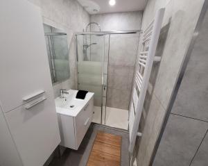 baño blanco con ducha y lavamanos en Le Cinéphile : Vivez comme une star à Hollywood !, en Creutzwald-la-Croix