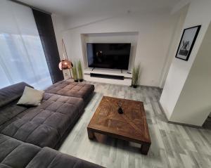 a living room with a couch and a large television at Le Cinéphile : Vivez comme une star à Hollywood ! in Creutzwald-la-Croix
