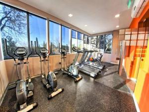 a gym with a row of cardio machines and windows at Guesthouse Luxury in Córdoba