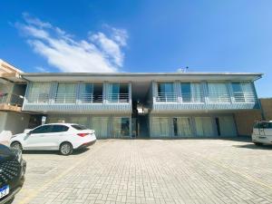 a white car parked in front of a building at Estúdio e Suítes com Piscina, churrasqueira, AR Split, WIFI - 6x sem juros no cartão in Porto Belo