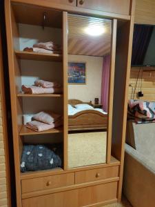 einen Holzschrank mit einem Spiegel im Schlafzimmer in der Unterkunft Садиба Маковиця in Jaremtsche