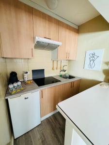 uma cozinha com armários de madeira e um frigorífico branco em Loft Azom em Vigo