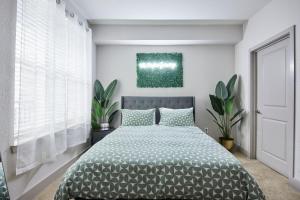 1 dormitorio con 1 cama y una pintura en la pared en Perfect Getaway Rentals LLC en Tampa