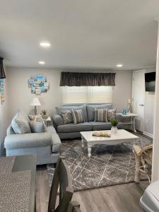 uma sala de estar com um sofá e uma mesa em Newly Renovated Ocean Block Duplex Located In The Heart Of Surf City, em Surf City