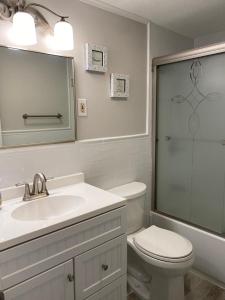 ein Badezimmer mit einem WC, einem Waschbecken und einem Spiegel in der Unterkunft Newly Renovated Ocean Block Duplex Located In The Heart Of Surf City, in Surf City