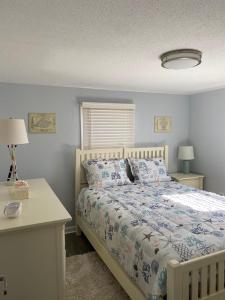 ein Schlafzimmer mit einem Bett, zwei Tischen und zwei Lampen in der Unterkunft Newly Renovated Ocean Block Duplex Located In The Heart Of Surf City, in Surf City