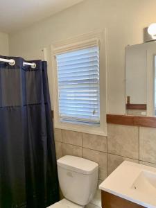 een badkamer met een zwart douchegordijn en een toilet bij Ocean Front Beach Haven Crest in Beach Haven Crest