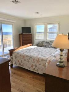 een slaapkamer met een bed en een tafel met een lamp bij Ocean Front Beach Haven Crest in Beach Haven Crest