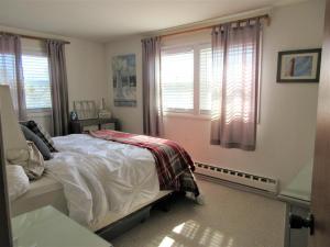 een slaapkamer met een bed en een raam bij Upgraded 2nd Floor Duplex In The Heart Of Harvey Cedars Close To The Bay Beach And The Ocean, in Harvey Cedars