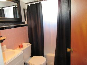 a bathroom with a toilet and a black shower curtain at Upgraded 2Nd Floor Duplex In The Heart Of Harvey Cedars Close To The Bay Beach And The Ocean in Harvey Cedars
