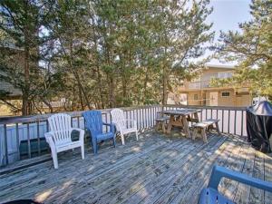 a deck with four chairs and a table and a grill at Buckley 1 in Beach Haven