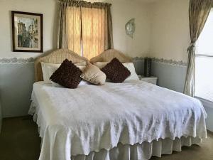 a bedroom with a white bed with pillows on it at Beachfront Vacation Rental On Lbi in Brant Beach