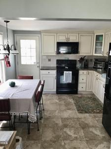 a kitchen with a table and a kitchen with white cabinets at Beachfront Vacation Rental On Lbi in Brant Beach