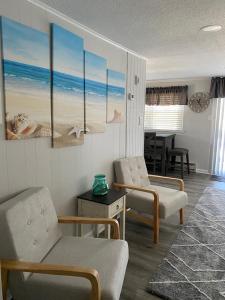 sala de estar con 2 sillas y mesa en Newly Renovated Duplex Located On The Ocean Block In The Heart Of Surf City,, en Surf City